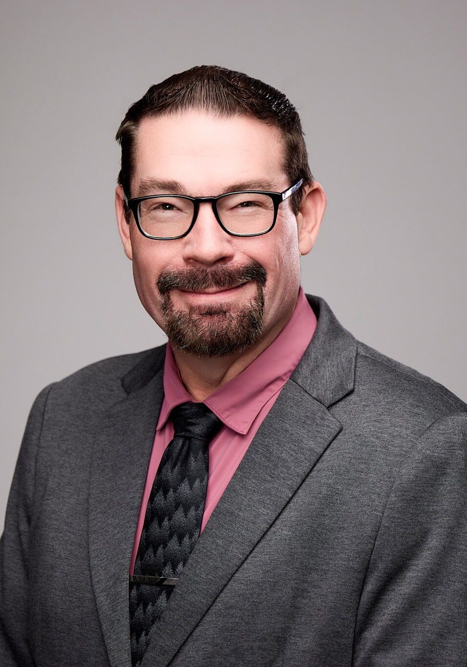 smiling man with glasses wearing a suit